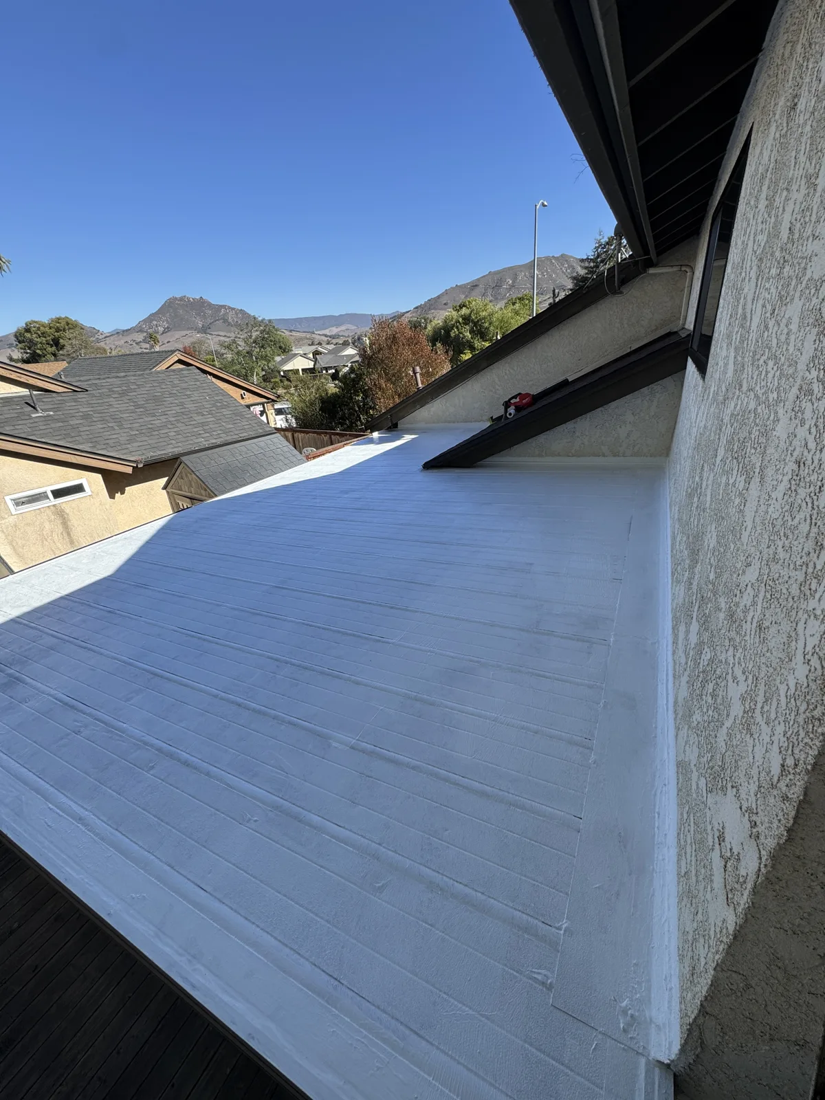 First coat of acrylic roof coating applied to the sunroom roof
