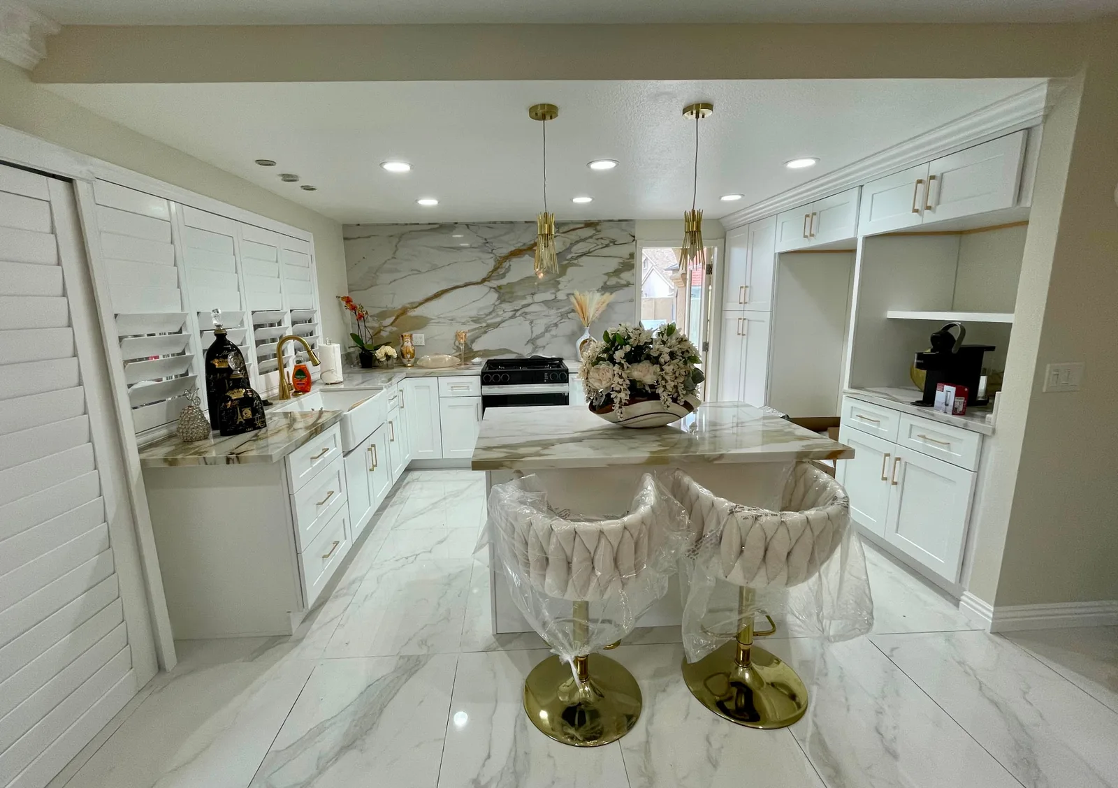 Finished kitchen remodel in San Luis Obispo by Mau & Co, with a marble island, white cabinetry, and gold fixtures