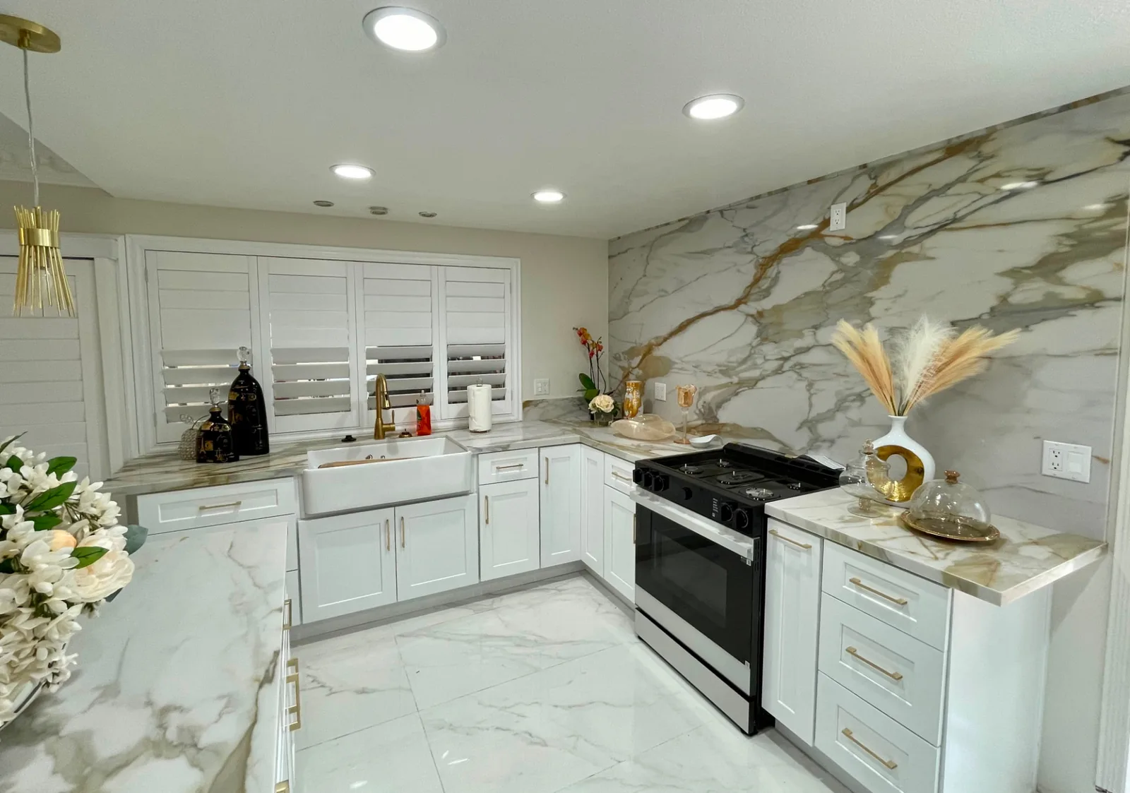 Range wall with full-height marble slab backsplash and white shaker cabinets in a San Luis Obispo kitchen remodel