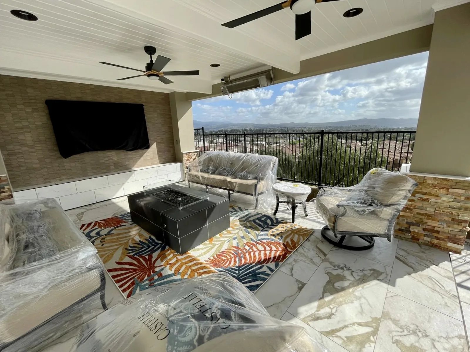 Patio lounge with fire table and stacked stone columns overlooking Los Angeles, built by Mau & Co